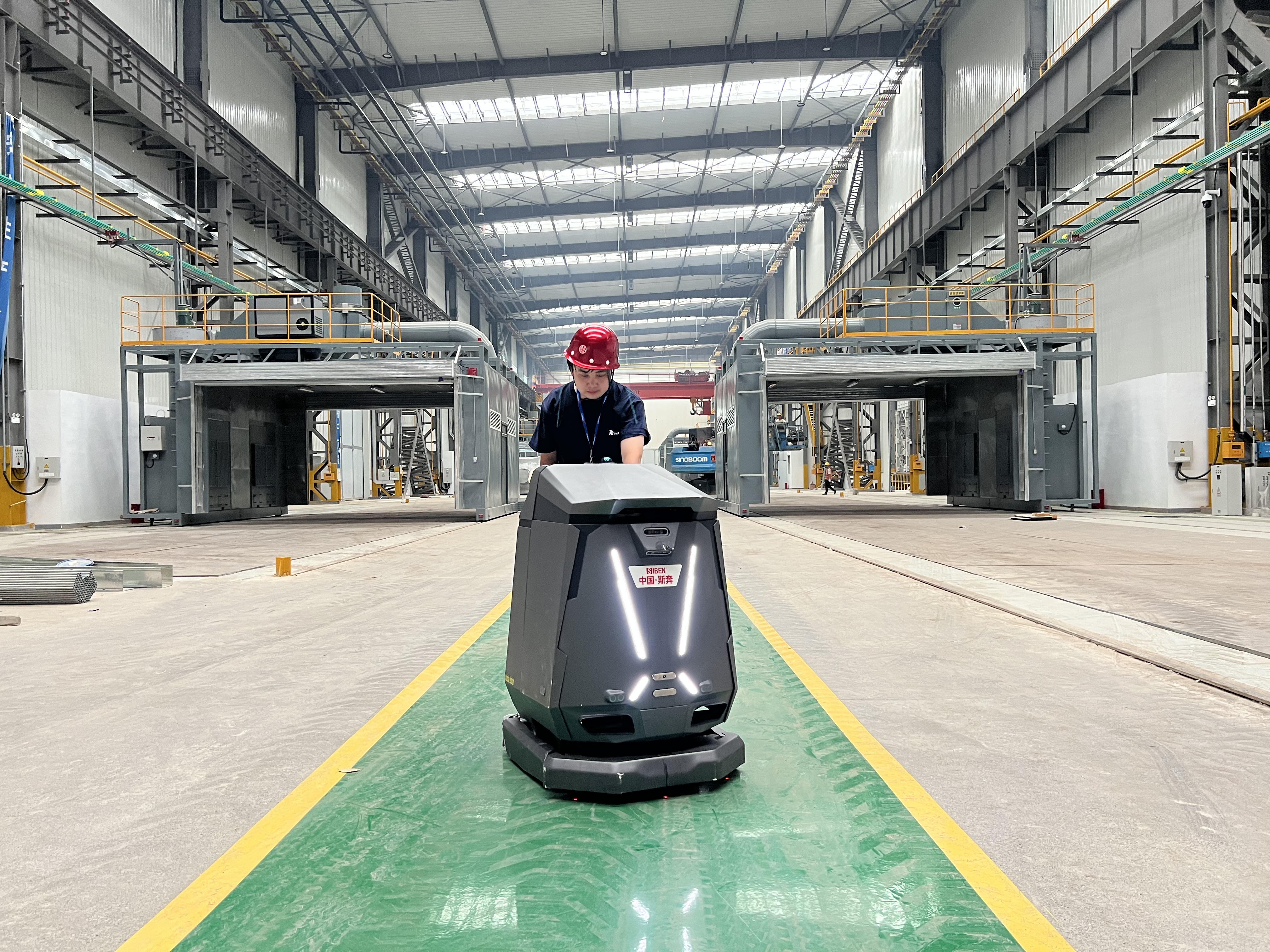 Siben Thunder God AMR cleaning robot operating in CITIC Heavy Industries manufacturing facility, demonstrating autonomous floor cleaning in heavy industrial environment